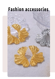 Detail of ginkgo leaf earrings with hammered texture on a glass tray display