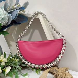 Detail of pink rhinestone crescent bag with sparkling crystal trim and smooth synthetic leather