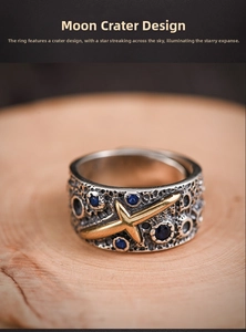 Macro detail of silver moon meteorite ring with blue gems and gold meteor on wood