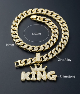 Close-up of 14mm gold Cuban chain with KING crown pendant and rhinestone details
