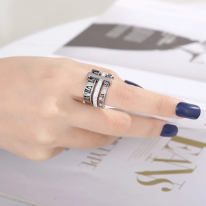 Detail of silver Roman numeral stacked rings with crystal inlay on a model hand