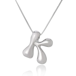 Macro shot of silver letter K pendant with polished finish on a delicate link chain