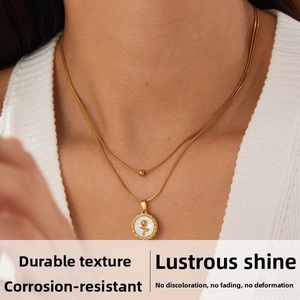 Gros plan d'un collier doré multicouche avec pendentif rose en nacre sur un mannequin