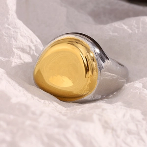 Detailed view of bicolor 18K gold plated ring on white textured art paper