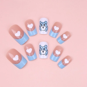Detail of nude and blue French press-on nails with white hearts and cartoon bear patterns