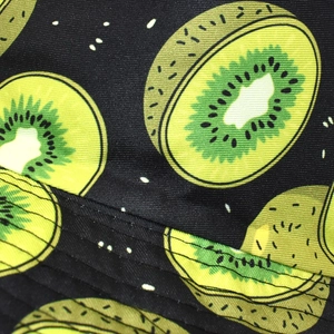 Vue détaillée du tissu du chapeau bob noir avec imprimé kiwi vert éclatant