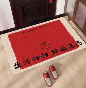 Detail of red and beige housewarming doormat with calligraphy on a wooden floor