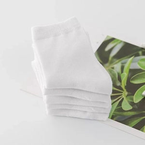 Stack of five pairs of white cotton ribbed crew socks for children on a clean background