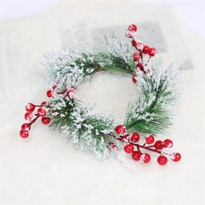 Detail of snowy artificial pine needles and red berries on a festive Christmas wreath