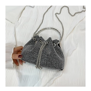 Close-up of a sparkling black rhinestone bucket bag with silver chain handle and drawstring