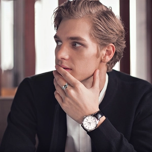 Close-up of a silver men's watch and a brushed titanium steel ring on a model's wrist