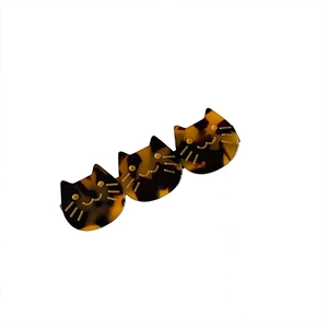 Three cat-shaped acetate hair clips in tortoise shell pattern with gold facial details