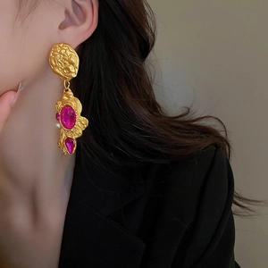 Macro detail of vintage baroque floral earrings with pink crystals and white pearls