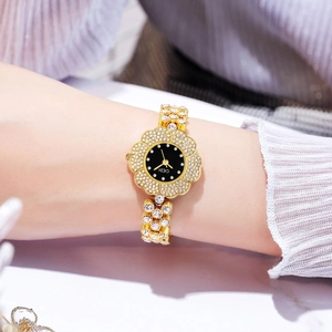 Dettaglio dell'orologio al quarzo dorato a forma di fiore con cinturino di diamanti