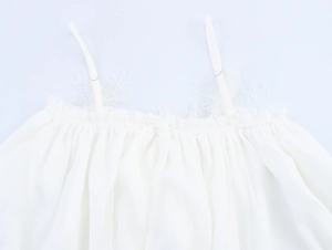 Detailed close-up of delicate lace straps and pleated texture on white chiffon dress