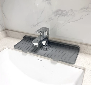 Gray silicone faucet splash guard mat used on bathroom vanity for drainage and soap holding