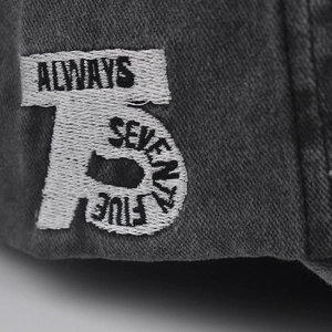 Macro shot of white 3D embroidery patch with ALWAYS 75 text on vintage baseball cap