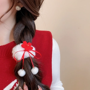 Detail of red flower hair scrunchie with soft white plush base and long hanging ribbons