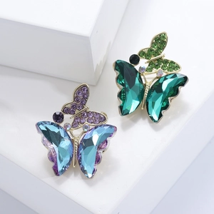 Elegant pair of crystal butterfly brooches with blue and green stones on gold alloy bases