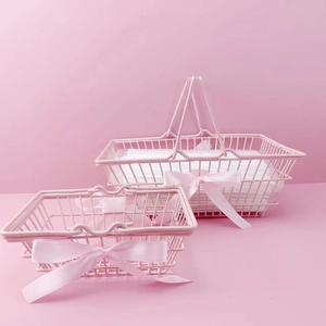 Detailed view of pink iron storage baskets in two sizes with decorative silk bows
