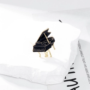 Broche piano en émail noir élégante avec bordure dorée sur un support en pierre