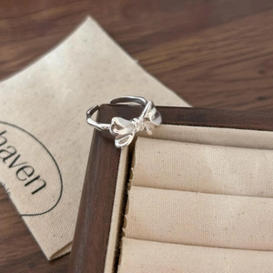 Detail of S925 sterling silver bow ring with adjustable open band on jewelry display