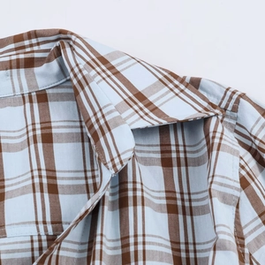 Close-up of light blue and brown plaid poplin fabric texture and stitching details