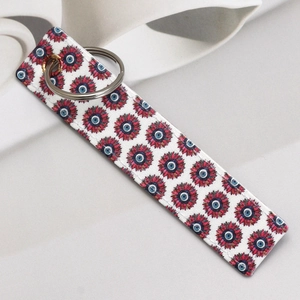 Detail shot of the long faux leather keychain with blue eye patterns and silver ring