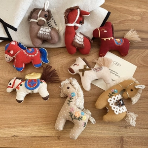 Detailed embroidery and knitted textures on handmade fabric horse brooches