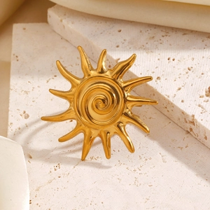 Vintage stainless steel sun ring with golden spiral center on beige stone base