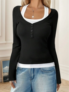Detalle de top de manga larga a capas en blanco y negro con cuello Henley de cinco botones