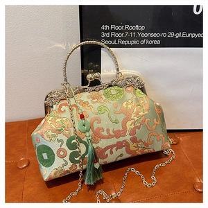 Detail of vintage green silk handbag with lion embroidery and dragon gold clasp