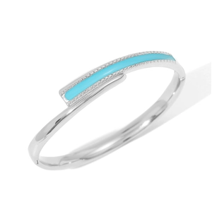 Detail of silver stainless steel bangle featuring light blue enamel inlay and geometric design