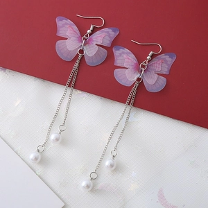 Vue détaillée des boucles d'oreilles papillon à pompon long avec tulle et perles