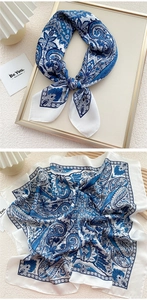 Close-up of blue paisley silk scarf with elegant pattern detail and satin finish