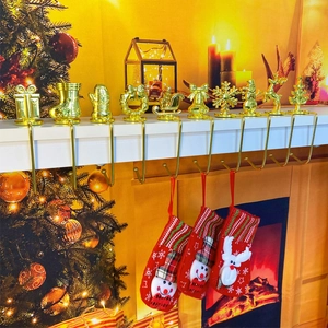 Golden Christmas stocking mantel hooks with festive reindeer and snowman figures