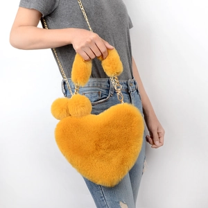 Ginger yellow heart-shaped faux fur crossbody bag with gold chain strap and pompom charms