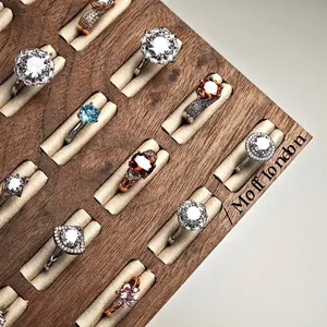 Walnut wood jewelry tray with various gemstone rings in silver and rose gold finishes