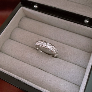 Macro shot of silver zircon twist ring in gray velvet jewelry box display
