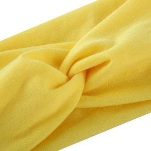 Detailansicht eines gelben Yoga-Stirnbands mit Knotendesign und weicher Stofftextur