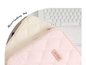 Detailed view of quilted laptop sleeve featuring chic diamond textures and a logo label