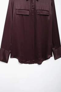 Flat lay of a deep purple satin long-sleeve shirt with pockets and glossy finish