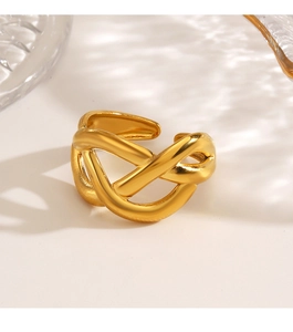 Detailed close-up of chunky gold-plated crisscross ring on minimalist white background