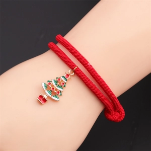 Detail of red braided Christmas bracelet featuring a green enamel Christmas tree charm