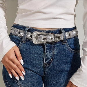 Detail of silver rhinestone belt with western buckle on blue denim jeans