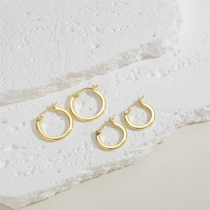 Set of two pairs of minimalist 14K gold plated hoop earrings on a stone display