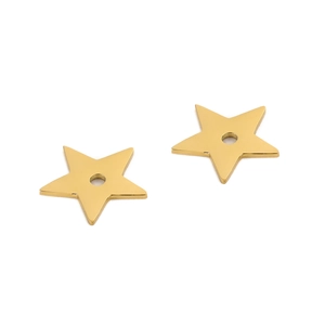 Macro shot of two gold star-shaped stainless steel pendants with center holes for DIY jewelry