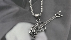 Close-up of silver titanium steel guitar pendant with rock-on skull hand on a metal chain