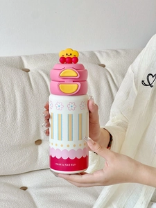 Gros plan d'une gourde mignonne avec paille et motifs floraux tenue à la main