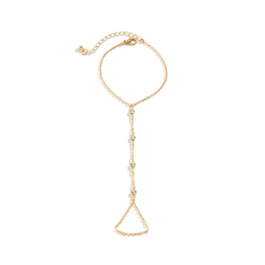 Detailed view of a gold-finish slave bracelet with rhinestones and pearl accents